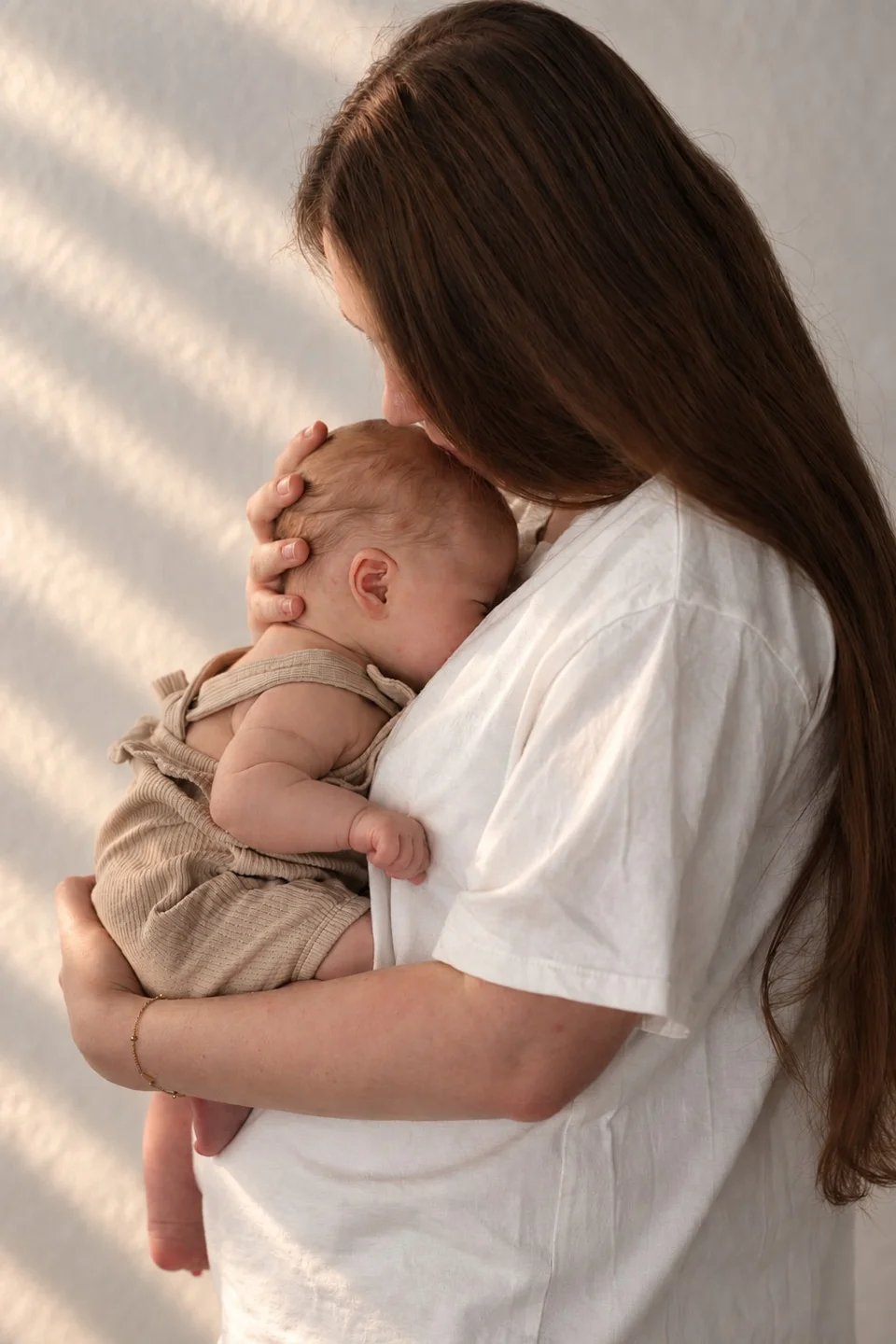 Mama hält ihr Baby im sanften Tageslicht